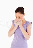 Attractive woman sneezing while standing