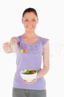 Good looking woman holding a bowl of salad while standing