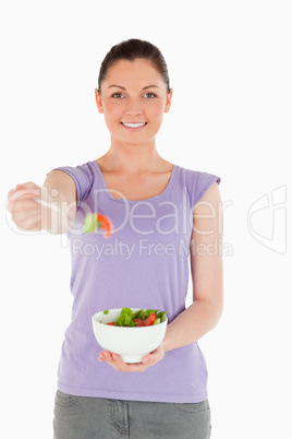 Attractive woman holding a bowl of salad while standing