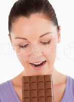 Portrait of a gorgeous woman eating a chocolate block while stan