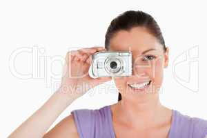 Portrait of an attractive woman using a camera while standing