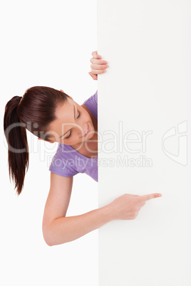 Beautiful female pointing at a copy space while standing