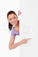 Charming female pointing at a copy space while standing