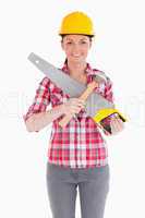 Pretty woman holding a saw while standing