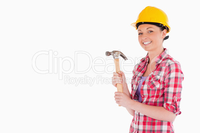 Attractive woman holding a hammer while standing