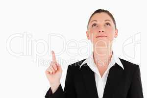 Charming woman in suit pointing at a copy space