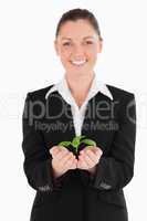 Beautiful woman in suit holding a small plant