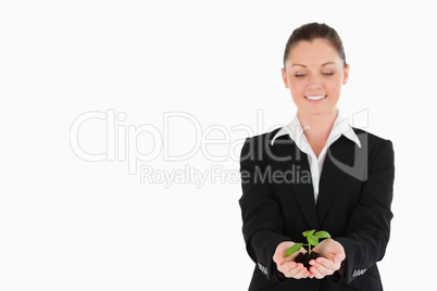 Pretty woman in suit holding a small plant