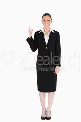 Good looking female in suit pointing at a copy space