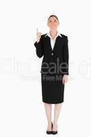 Charming female in suit pointing at a copy space