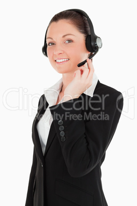 Portrait of an attractive woman in suit using headphones and pos