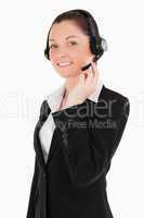 Portrait of an attractive woman in suit using headphones and pos