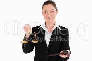 Beautiful woman in suit holding scales of justice and a gavel