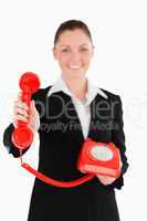 Beautiful woman in suit holding a red telephone