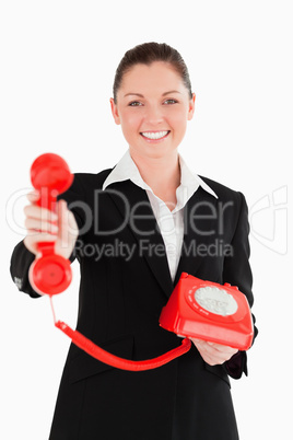 Good looking woman in suit holding a red telephone