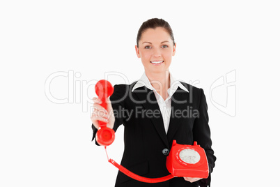 Charming woman in suit holding a red telephone
