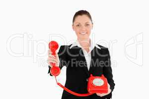 Pretty woman in suit holding a red telephone