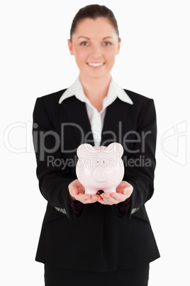 Beautiful woman in suit holding a pink piggy bank