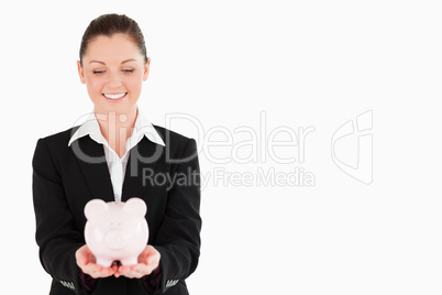 Gorgeous woman in suit holding a pink piggy bank Gorgeous woman in suit holding a pink piggy bank