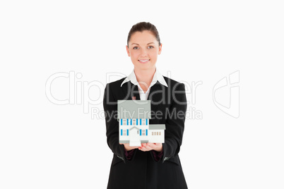 Pretty woman in suit holding a miniature house