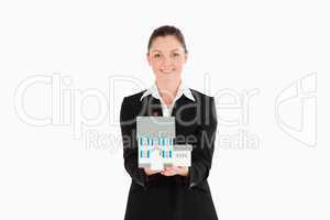 Pretty woman in suit holding a miniature house