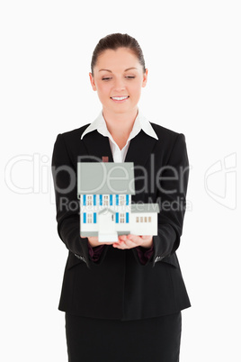 Beautiful woman in suit holding a miniature house