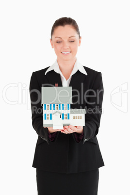 Attractive woman in suit holding a miniature house