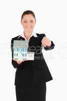Attractive woman in suit holding keys and a miniature house