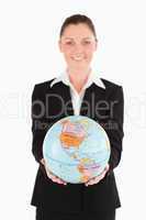 Good looking female in suit holding a globe