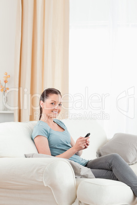 Charming woman writing a text on her mobile phone