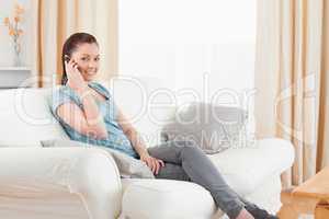 Attractive woman on the phone while sitting on a sofa