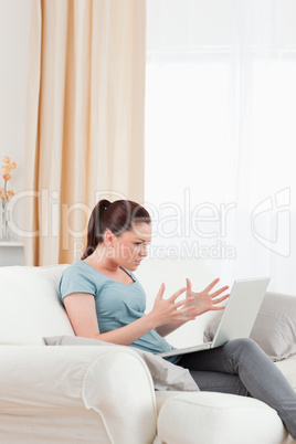 Good looking upset woman gambling with her computer while sittin