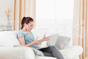 Charming upset woman gambling with her computer while sitting on