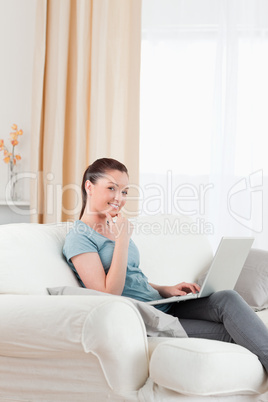 Gorgeous woman relaxing with her laptop while sitting on a sofa