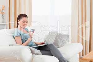 Lovely woman making an online payment with her credit card while