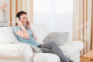Beautiful woman relaxing with headphones while sitting on a sofa