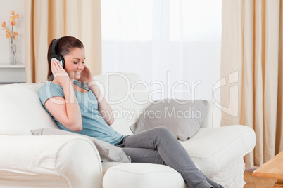 Gorgeous woman relaxing with headphones while sitting on a sofa