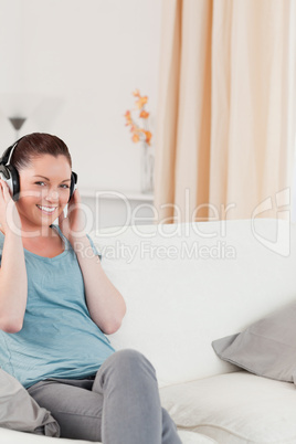 Good looking woman relaxing with headphones while sitting on a s