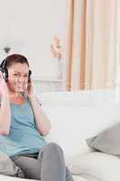 Good looking woman relaxing with headphones while sitting on a s