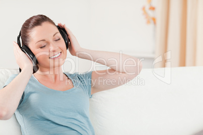 Pretty woman relaxing with headphones while sitting on a sofa