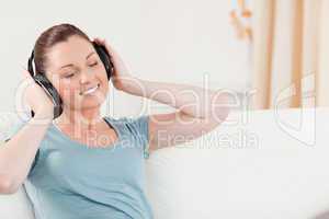 Pretty woman relaxing with headphones while sitting on a sofa