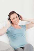 Cute woman relaxing with headphones while sitting on a sofa