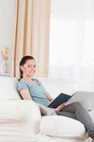 Attractive woman reading a book while sitting on a sofa
