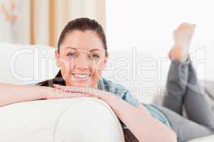 Attractive woman posing while lying on a sofa