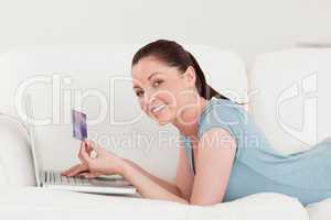 Side view of a beautiful woman making an online payment with her