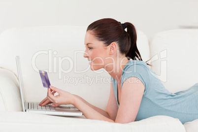 Side view of an attractive woman making an online payment with h