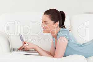 Side view of a good looking woman making an online payment with