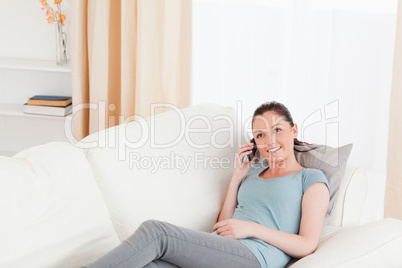 Lovely woman on the phone while lying on a sofa