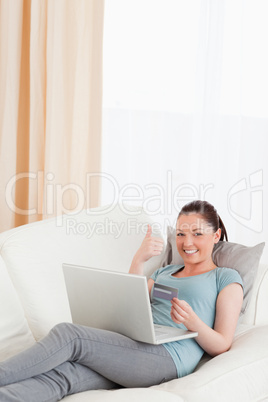 Charming female making an online payment with her credit card wh