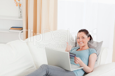 Attractive female making an online payment with her credit card